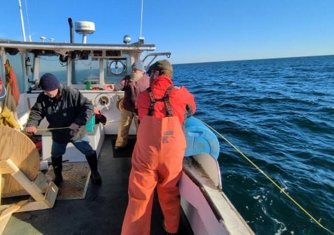 Fishermen and Kelson engineers handle prototype composite line aboard a working boat during an early field trial